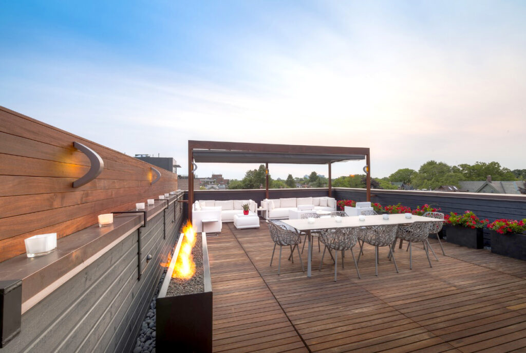 Modern rooftop terrace with seating and fire pit.
